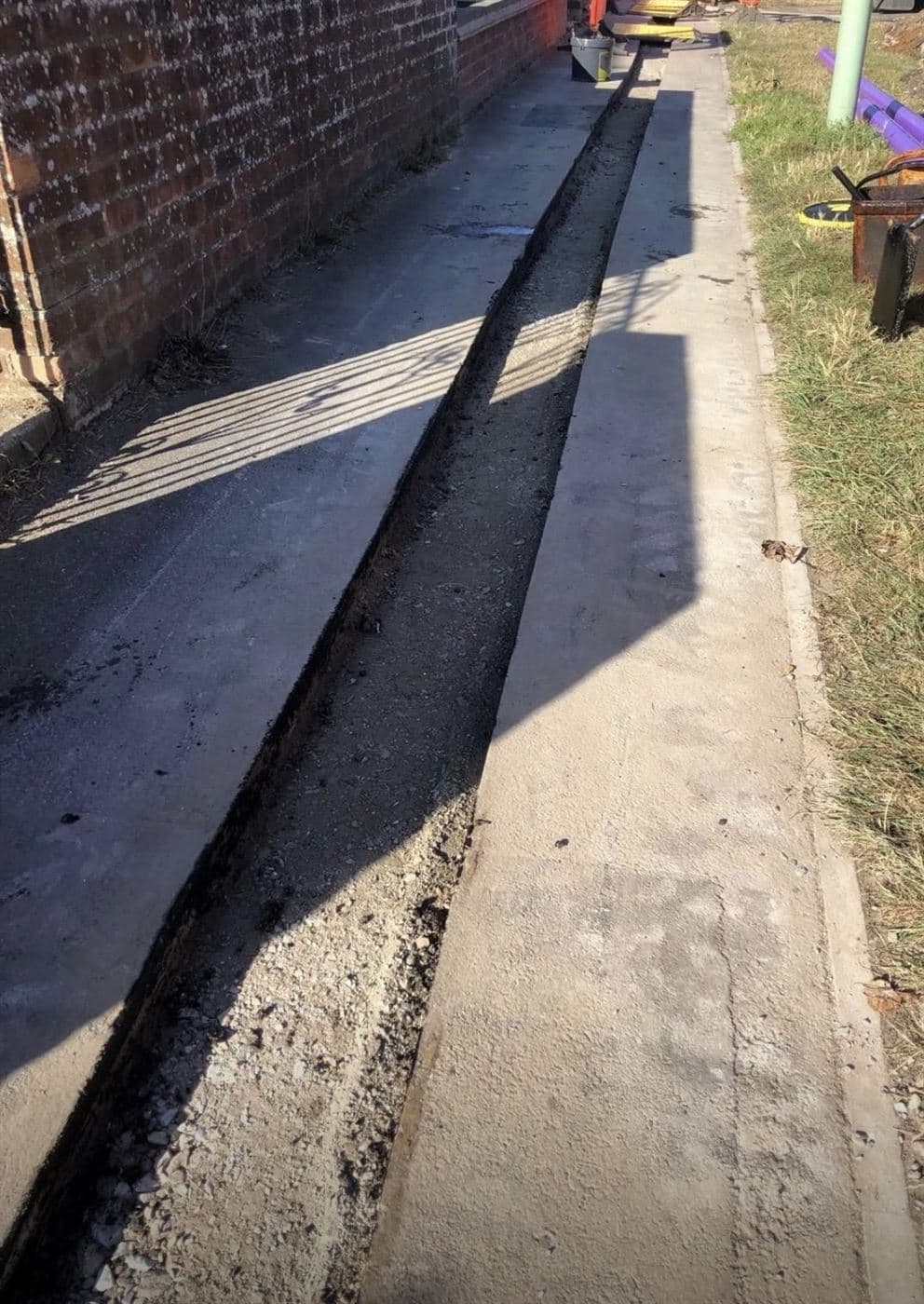 Tarmac reinstatement strip laid over a completed duct route in a footway